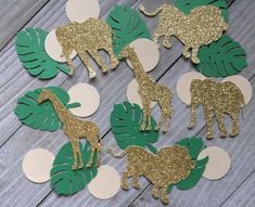 gold and green paper cut outs with giraffes, elephants, and palm leaves