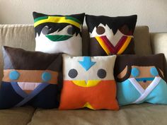 four pillows with different designs on them sitting on a couch