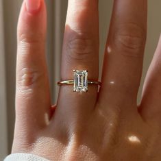 a woman's hand with a ring on it and a diamond in the middle