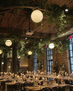 the tables are set up with candles and greenery for an elegant dinner or function