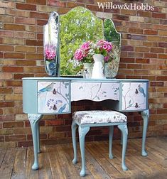 a blue vanity with flowers on it and a mirror