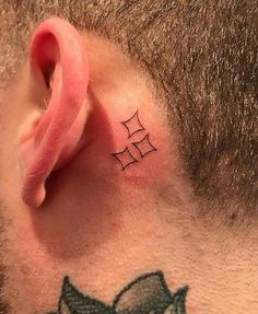 a man with a small tattoo on his ear