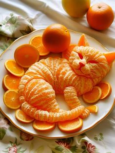 an orange cat made out of fruit on a plate