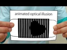 a person holding up a piece of paper with the word animated optical illusion on it