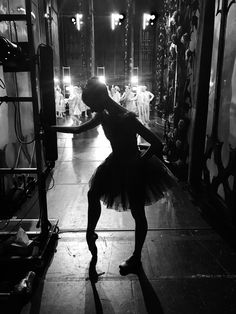 a ballerina is standing in the middle of a dance studio