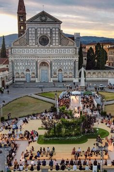 an aerial view of people sitting on steps in front of a building with a fountain