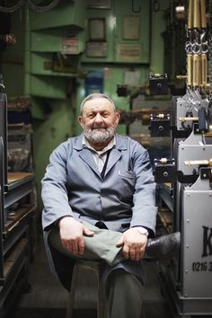 a man sitting in a chair with his feet on the ground next to some type of machine