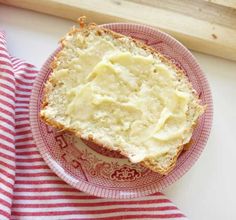 a piece of bread sitting on top of a red and white plate