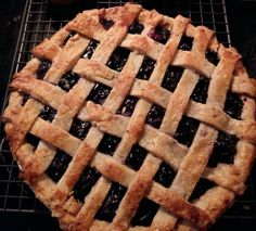 a blueberry pie sitting on top of a cooling rack