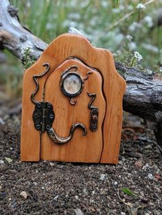 a small wooden sculpture with an elephant's head in the shape of a door