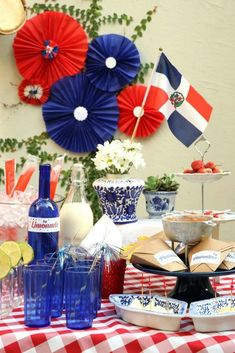 a table topped with plates and drinks on top of a red white and blue checkered table cloth