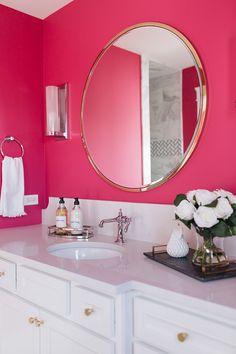 a bathroom with pink walls and white cabinets is featured on the instagram page for new construction farmhouse