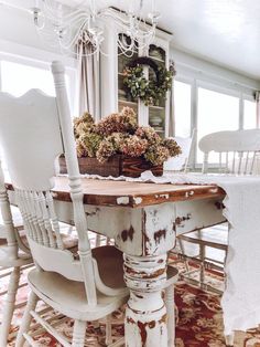 a dining room table and chairs with flowers in the centerpieces on top of it