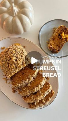 pumpkin streusel bread on a plate next to a white pumpkin