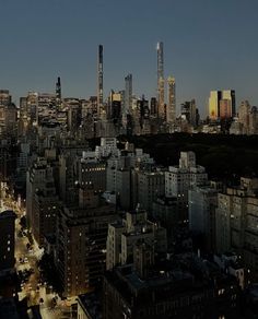 the city skyline is lit up at night with skyscrapers in the foreground and lights on all sides