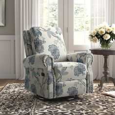 a blue and white chair sitting on top of a rug in front of a window