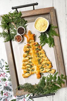 a christmas tree made out of puff pastry on a tray with other food and condiments