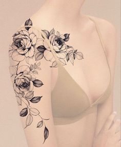 a woman's arm with flowers on it and a bra underneath her breast is shown