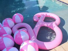 pink and white inflatable floats next to a swimming pool with the number 80 on it