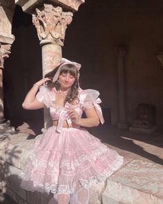 a woman in a pink dress is posing for the camera