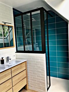 a bathroom with two sinks and a shower stall in it's corner, next to a tiled wall