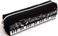 a black pencil case with music notes and cats on the piano keys printed on it