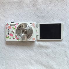 a white camera sitting on top of a bed