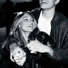 a man and woman laughing together in black and white