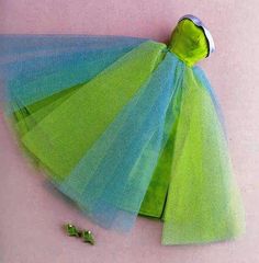 there is a green and blue tulle skirt on the floor next to two screws