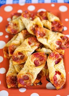 pepperoni and cheese pastries on an orange plate with polka dot tablecloths