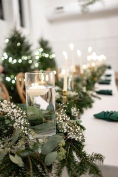 a table with candles and greenery on it