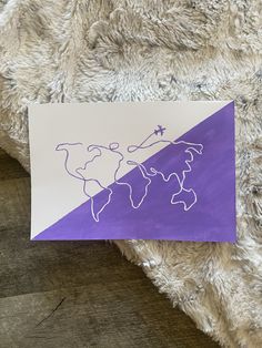 a piece of paper with a drawing of the world on it sitting on a furry surface