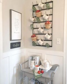 there is a small table with cups and teapots on the rack above it