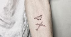 a man's arm with a small tattoo on it and an airplane in the middle