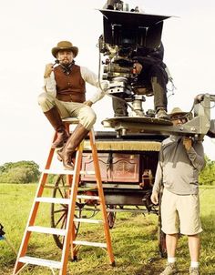 two men sitting on top of a camera set