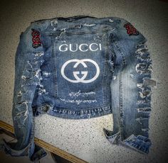 a denim jacket with the gucci logo on it is sitting on a counter top