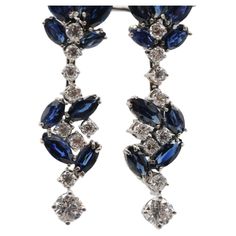 Step into the realm of luxury with these majestic 18k white gold drop earrings adorned with sapphires and diamonds. Each side of the earrings features brilliant-cut diamonds totaling approximately 0.72 carats, with a clarity of VS1 and a color grade of G. The diamonds are expertly cut with a grade of Very Good, ensuring optimal sparkle and brilliance. Complementing the diamonds are 9 navette-cut sapphires on each earring, totaling approximately 0.80 carats overall. These deep blue sapphires add Luxury White Gold Sapphire Diamond Earrings, Luxury Sapphire Dangle Earrings, Luxury Sapphire Gemstone Diamond Earrings, Sapphire Diamond-cut Earrings, Luxury Polished Sapphire Earrings, White Gold Drop Earrings, French Aesthetic, Aesthetic Movement, Gold Drop Earrings