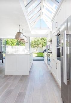 an open kitchen with white cabinets and stainless steel appliances, is seen in this image