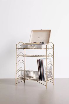 a record player sitting on top of a metal shelf next to a cd rack with records