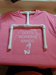 a pink t - shirt with the words god's working hands on it