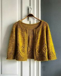 a yellow sweater hanging on a white door