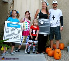 a group of people standing next to each other in front of a house with halloween decorations