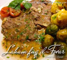 a white plate topped with meat, potatoes and veggies covered in gravy