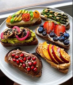 a white plate topped with sandwiches covered in fruit and veggies on top of it