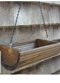 a wooden bird feeder hanging from a chain