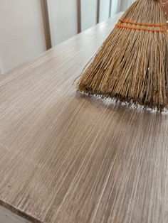 a broom sitting on top of a wooden table