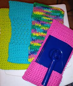 three crocheted dishcloths and a blue spoon on a white table top