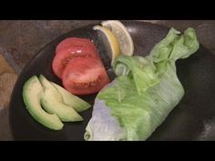 lettuce, tomatoes and avocado on a black plate