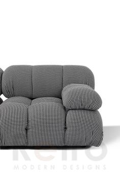 a black and white checkered couch sitting on top of a wooden table next to a lamp