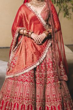 Editor's Note Vermillion Silk Lehenga Choli With Soft Tulle Dupatta Gold Zari, Mokaish, Resham , Crystal And Dabka Embellishments. Color: Red Fabric: Silk Care: Dry Clean Only About the Designe... Red Gota Work Choli For Reception, Red Floor-length Lehenga With Gota Work, Red Cutdana Traditional Wear For Reception, Red Art Silk Lehenga With Gota Work, Traditional Sets With Gota Work For Reception, Traditional Gota Work Sets For Reception, Red Kundan Sets For Transitional Season, Red Semi-stitched Lehenga With Gota Work, Traditional Red Sets With Gota Work